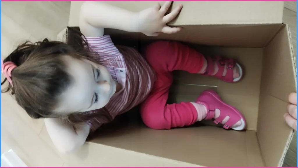 Dobozutazás. Kislány dobozban ülve “utazik”