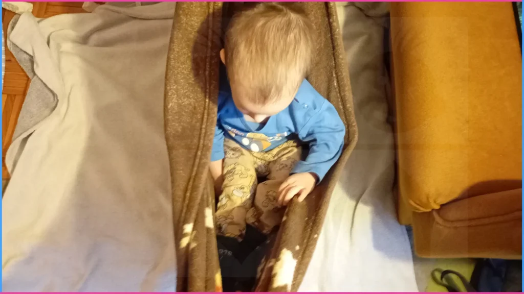 Takaróba hinta. Kisfiút takaróban hintáztatják