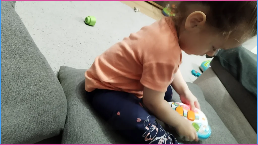 Vigyázz a peremen! Kislány párnán ülve játszik.