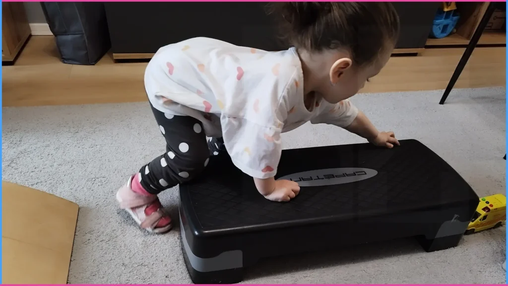 Kislány step padra mászik